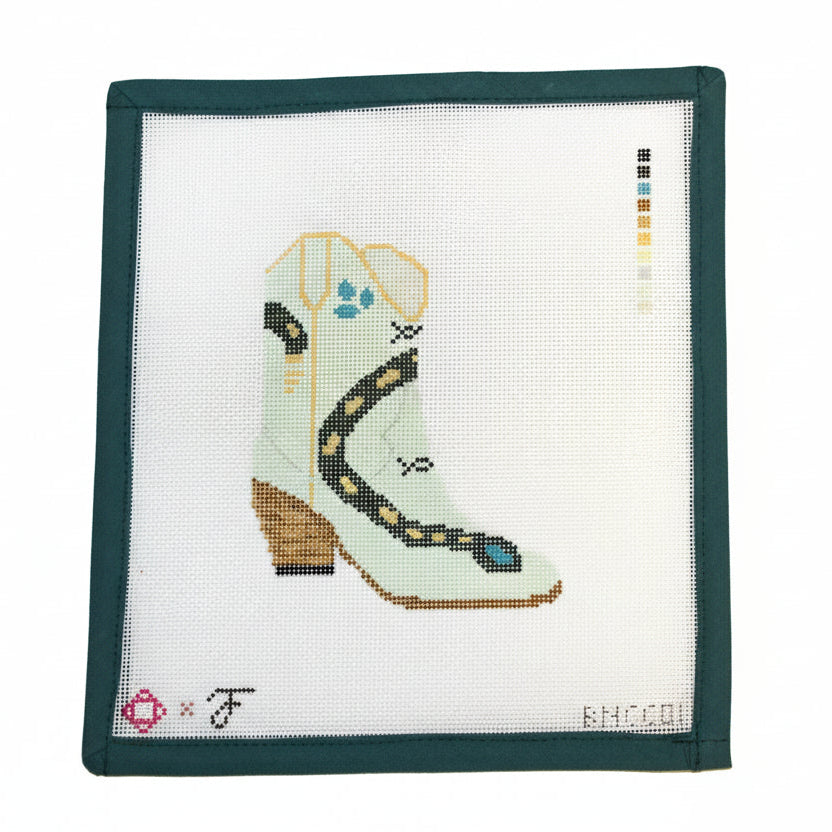 Cross-stitched boot design on fabric with a color chart